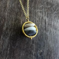 Have the beauty of nature on you with this beach stone necklace. Delicate but strong, symbolizing the inner strength, just like the power of the rocks. This necklace is created with a variety of hand picked stones from greek beaches. The necklace is created in high quality 24K gold plated sterling silver. The circle is approx. 14 mm / 0.55". Each necklace is unique, like the beautiful pebbles that it is created with. The beach pebbles have the colours of earth, white, black, gray, brown, beige. Natural Rock Necklace, Cairn Necklace, Beach Stones Jewelry, Greek Beaches, Pebble Pendant, Pebble Necklace, Raw Stone Necklace, Beach Pebbles, Rock Necklace