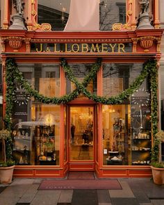 a store front with wreaths and decorations on the windows