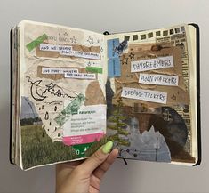 a hand holding an open book with torn paper and stickers all over the pages