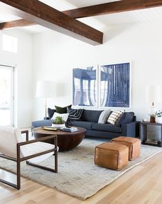 a living room filled with lots of furniture and paintings on the wall above it's fireplace