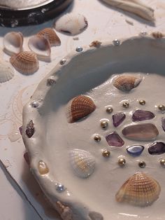 there are many seashells in the bowl on the table