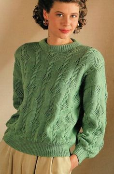 a woman wearing a green sweater and tan pants