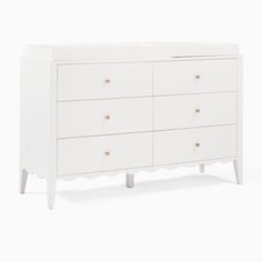 a white dresser with four drawers and two handles on the top, in front of a white background