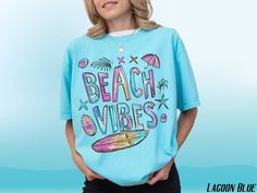 Dive into vacation mode with our 'Beach Vibes T-Shirt,' a must-have for every ocean lover featuring a colorful summer surfboard and palm trees design. Ideal for any tropical getaway, this vibrant tee blends stylish beachwear with a comfy unisex fit, perfect for surfers and beach enthusiasts alike. 𝐂𝐎𝐋𝐎𝐑𝐒 Butter Black Blossom Chalky Mint  Lagoon Blue Violet Watermelon 𝘔𝘦𝘴𝘴𝘢𝘨𝘦 𝘶𝘴 𝘧𝘰𝘳 𝘢𝘷𝘢𝘪𝘭𝘢𝘣𝘪𝘭𝘪𝘵𝘺 𝘰𝘧 𝘢𝘥𝘥𝘪𝘵𝘪𝘰𝘯𝘢𝘭 𝘤𝘰𝘭𝘰𝘳𝘴 𝐒𝐈𝐙𝐄 𝐂𝐇𝐀𝐑𝐓 See photos for size chart 𝐏𝐑𝐎𝐃𝐔𝐂𝐓 𝐃𝐄𝐓𝐀𝐈𝐋𝐒 ✨ 100% ring-spun US cotton ✨ Medium fabric (6.1 oz/yd² (206.8 g/m  ✨ Relaxed Fit ✨ Gildan is a proud member of the US Cotton Trust Protocol ensuring ethical and sustainable means of production 𝐂𝐀𝐑𝐄 𝐈𝐍𝐒𝐓𝐑𝐔𝐂𝐓𝐈𝐎𝐍𝐒 👚 Machine wash: cold (max 30C Multicolor Tops For Surfing, Beach Season, Multicolor Tops For Surfing Beach Season, Fun Multicolor Beach T-shirt, Blue Surfing T-shirt For Beach Season, Blue Beachwear T-shirt With Graphic Print, Blue Graphic Print Beachwear T-shirt, Blue Graphic Print T-shirt For Beach Party, Blue Graphic Print T-shirt For Beachwear, Blue Letter Print T-shirt For Beach Party