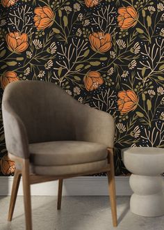 two chairs in front of a wall with orange and black flowers on it, next to a white toilet