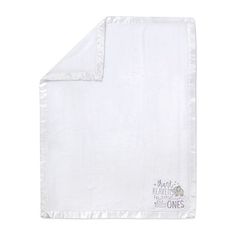 the white blanket is folded up on top of the pillow case, which has an embroidered logo