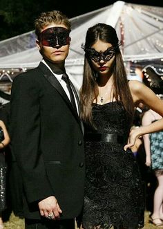 a man and woman dressed up in masquerades at an outdoor event together