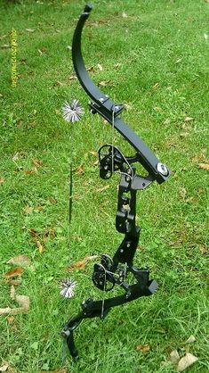 a bow that is sitting on the ground in the grass with its arrow attached to it