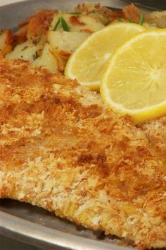 fish with lemon slices and potatoes in a pan