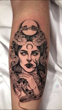 a woman's face with snakes around her head on the leg, and she is holding