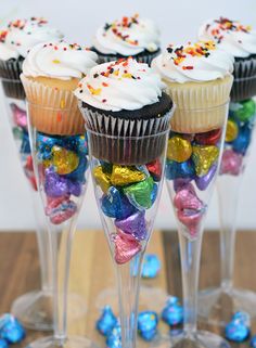 some cupcakes and candy in wine glasses on a table with the words candy flute party favors