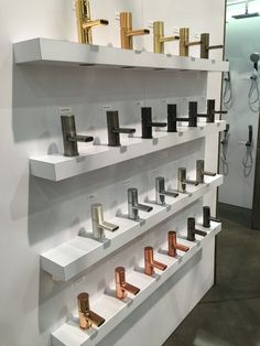 several different types of faucets are on display in a room with white shelving