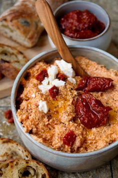 a bowl filled with food next to some bread