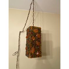 a piece of food hanging from a chain on the wall next to a white wall