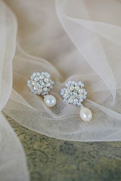 the bride's earrings are adorned with pearls