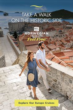 a man and woman are walking down the stairs in front of an old european city