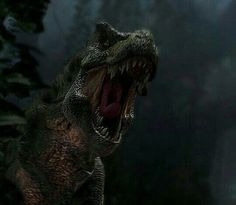 a dinosaur with its mouth open and it's teeth wide open in the dark