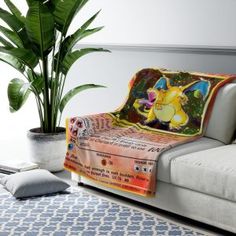 a couch with a pokemon blanket on top of it next to a potted plant