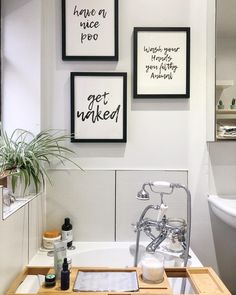 three framed pictures hang on the wall above a bathtub