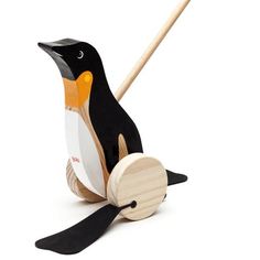 a black and white penguin with a wooden stick