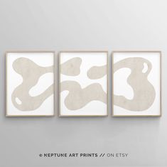 three abstract paintings hanging on the wall next to each other in white and beige colors