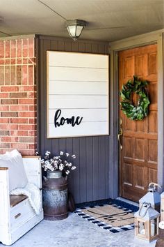 a welcome sign on the front door of a house with a wreath and flower pot