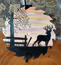 a piece of wood that has been painted with an image of a deer on it