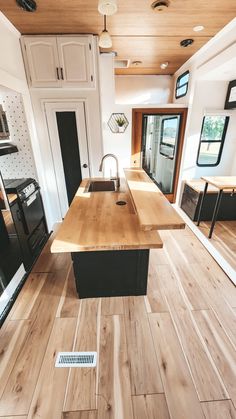 a kitchen with wood flooring and white cabinets in a mobile home that's for sale