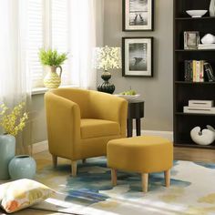 a yellow chair and ottoman in front of a bookcase with pictures on the wall