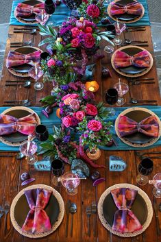 the table is set with pink and purple flowers