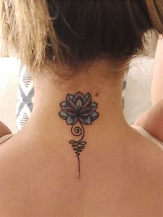 a woman's back neck with a flower tattoo on her left side ribcage