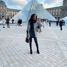 a woman standing in front of a pyramid