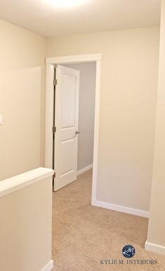 an empty room with white doors and carpeted flooring in front of the door