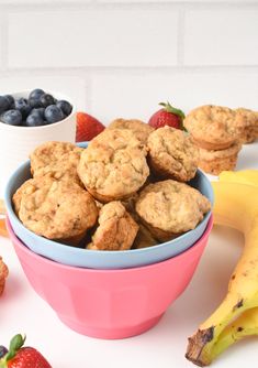 baby cereal muffins in a pink bowl with blueberries and strawberries on the side