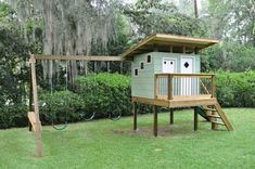 a tree house with a swing set in the yard