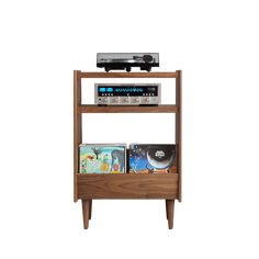 a wooden shelf with cd's and an audio player on top, against a white background