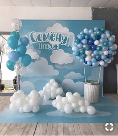 balloons are floating in the air near a blue and white backdrop