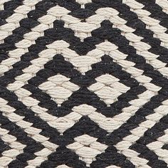 the black and white rug is woven with rope