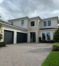 a large white house with two garages on the driveway