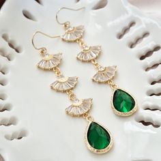 "Long boho bridal earrings with emerald green stones, long Art Deco earrings, gold statement earrings, drop earrings, fan earrings Dazzle at your wedding or party with these 1920s inspired long statement earrings with emerald green stones. These Art Deco earrings feature fan shaped sparkly crystals with emerald green teardrop stones at its ends. Complete your look with matching this matching fan necklace : https://www.etsy.com/YsmDesigns/listing/1309341599/ DIMENSION : ------------------- Earrin Emerald Green Dangle Earrings, Green Dangle Chandelier Earrings For Weddings, Bohemian Green Chandelier Earrings For Wedding, Bohemian Green Bridal Earrings For Wedding, Green Emerald Dangle Chandelier Earrings, Green Drop Earrings For Wedding, Green Teardrop Dangle Earrings For Wedding, Green Teardrop Earrings For Wedding, Green Bohemian Earrings For Wedding