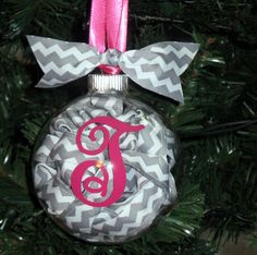 a monogrammed ornament on a christmas tree with pink ribbon and bow