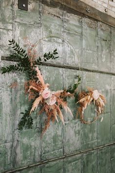 two wreaths with flowers hanging on a wall