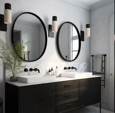 a bathroom with two sinks and mirrors above them