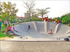 people are sitting on the edge of a skateboard ramp