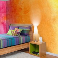 a bedroom with colorful walls and a bed in the corner, next to a night stand