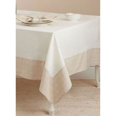 a table with a white plate and two bowls on it, sitting in front of a beige wall