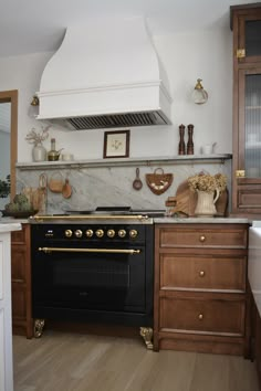 a stove top oven sitting inside of a kitchen next to wooden cabinets and counter tops