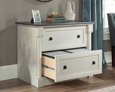 a white dresser with two drawers and a clock on the wall