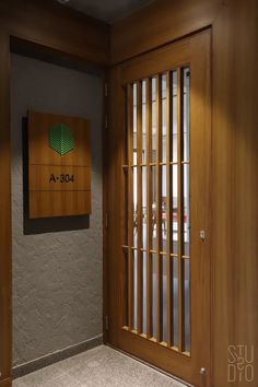 the entrance to an office building with wooden paneling and metal bars on the doors