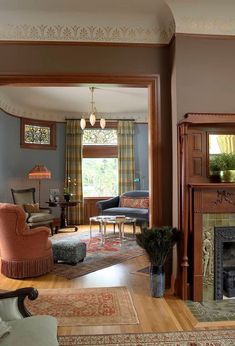 a living room filled with furniture and a fire place under a window next to a fireplace